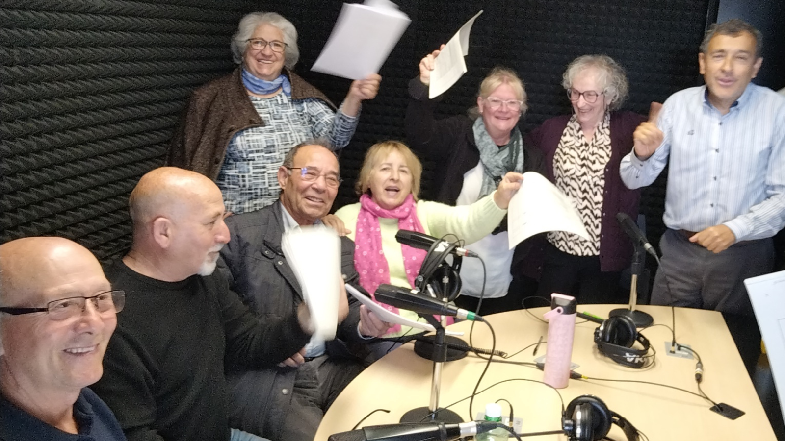 Un grup de 8 persones a un estudi de ràdio. 