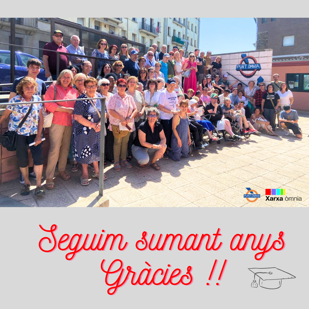 Imatge de l'acte de lliurament de persones participant del punt Òmnia. Apareix un grup nombrós de persones a unes escales amb el logo d'Òmnia de fons. 
